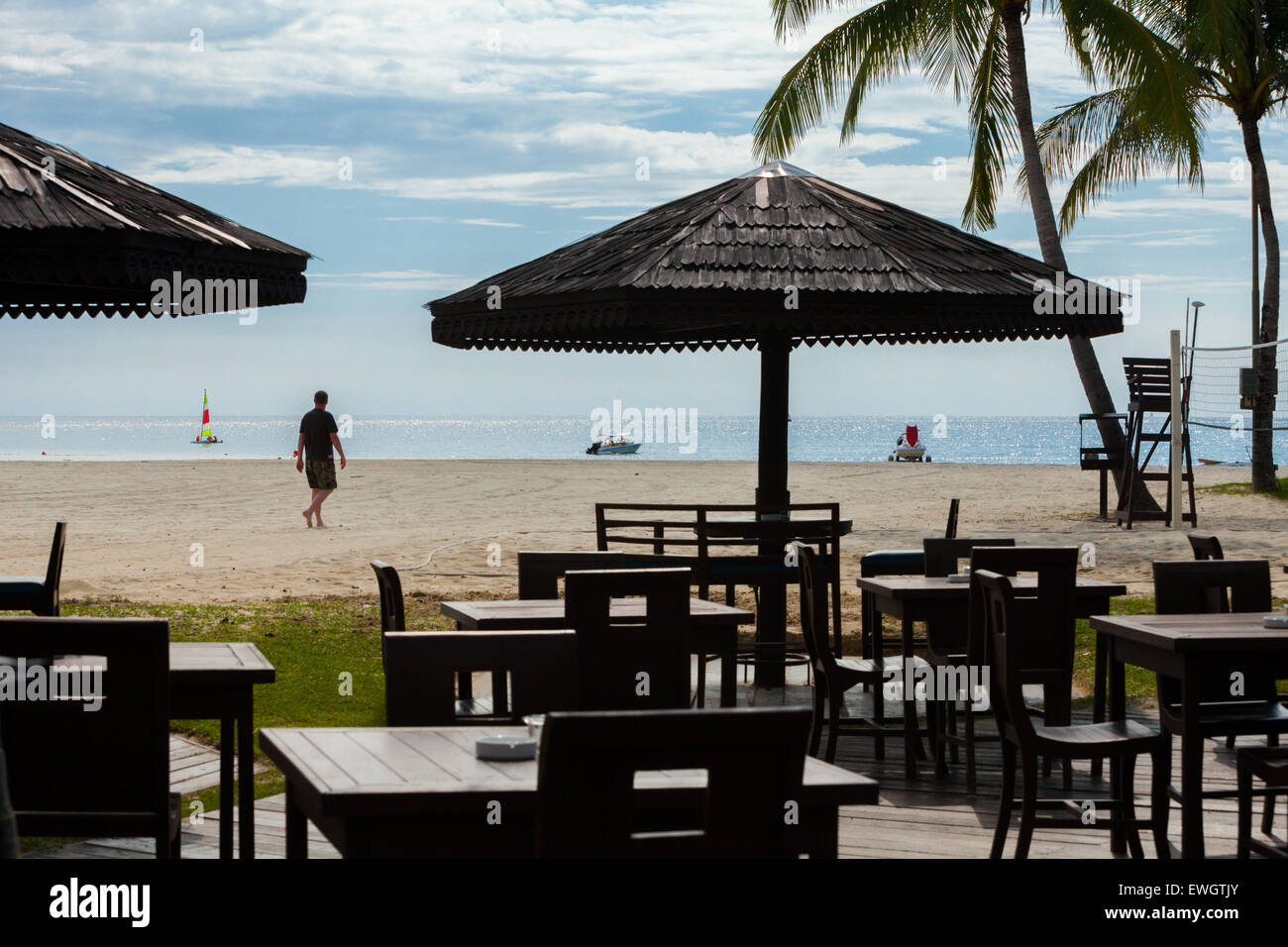 View of a cafe overlooking sandy beach and sea at Shangri-la Rasa Ria beach resort in Kota Kinabalu, Sabah, Malaysia. Stock Photo