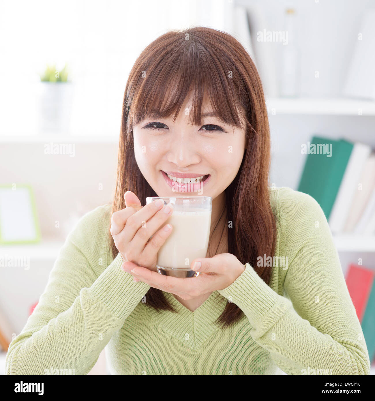 Portrait of happy Asian girl drinking soy milk as breakfast. Young