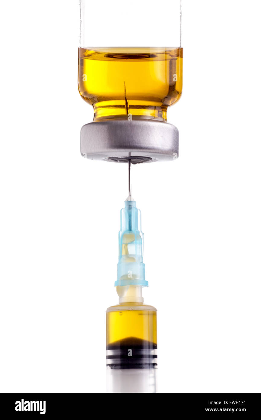 Syringe being filled with yellow liquid from medicin vial, ready for injection. Isolated on white Stock Photo