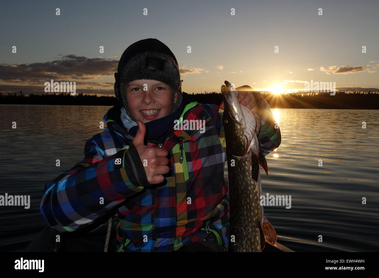 Lessebo, Sweden, boy proudly displays his self-caught pike on Lake Rottnen Stock Photo