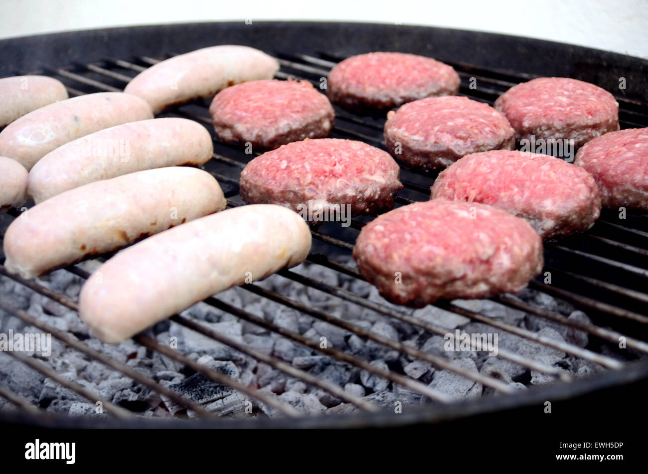 Sausages and burgers cooking on a barbecue Stock Photo Alamy
