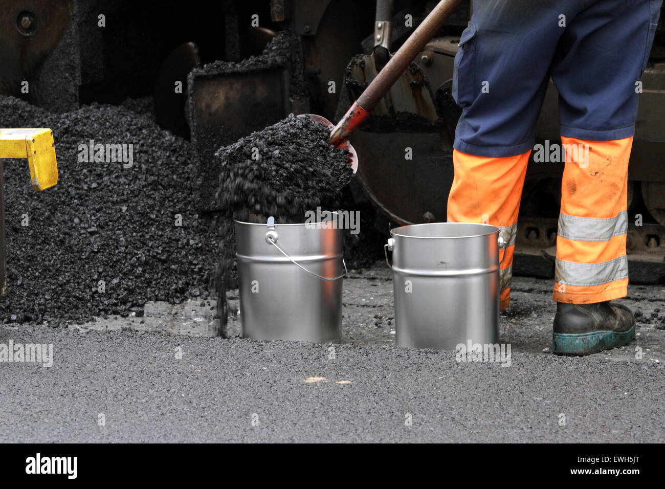 Berlin, Germany, asphalt mix is placed in a bucket Stock Photo