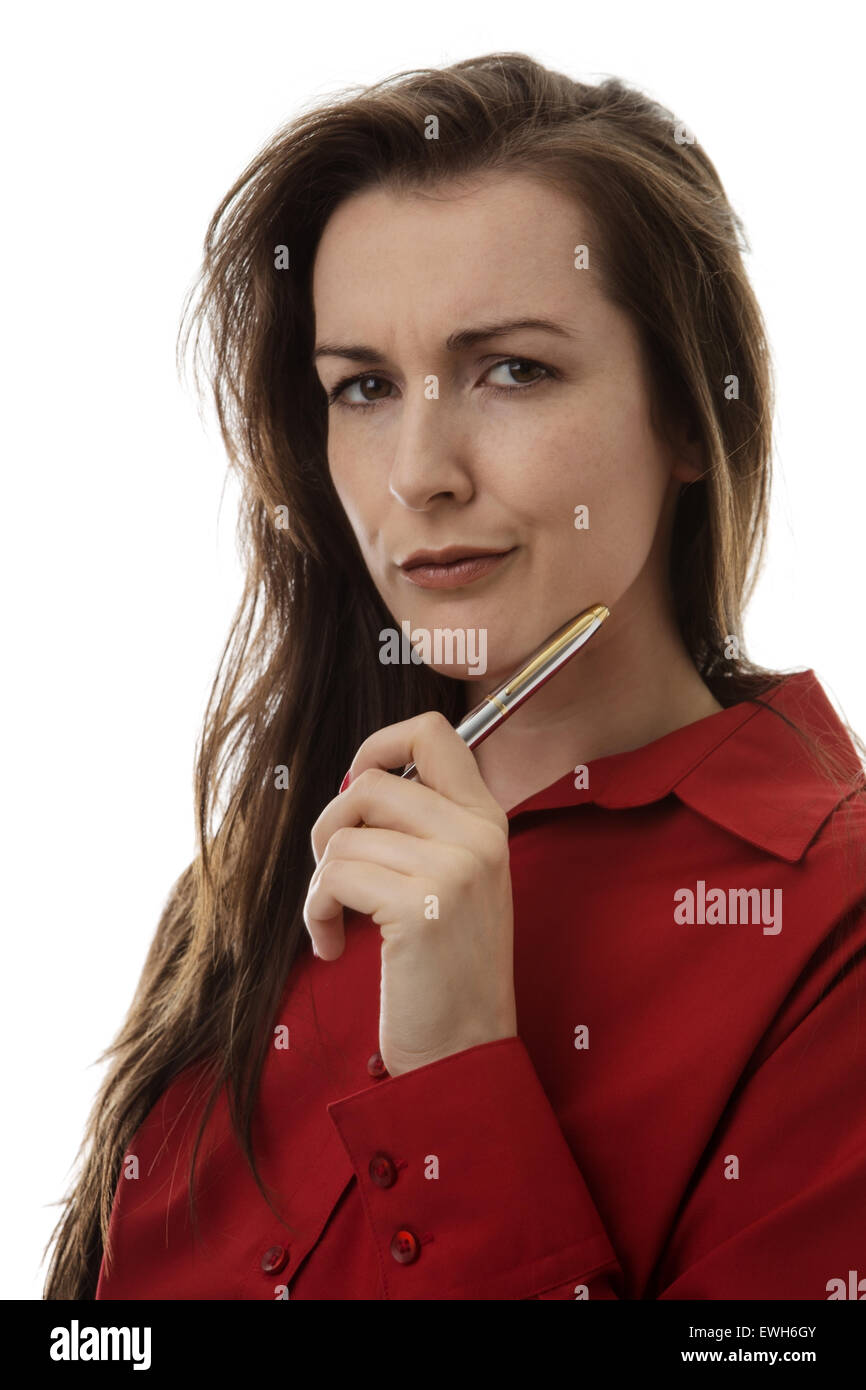 working woman deep in thought holding a pen up to her face Stock Photo