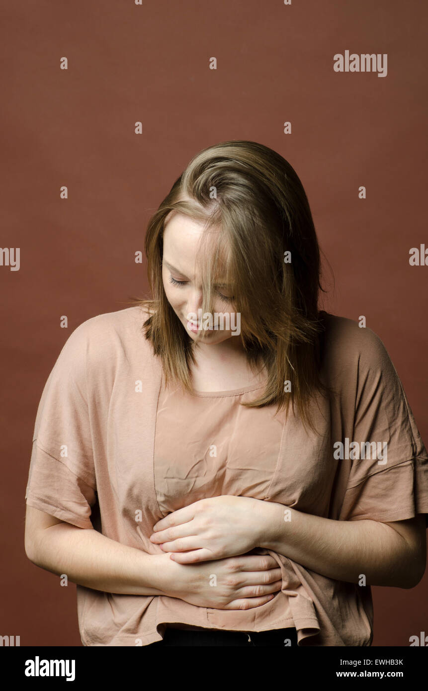Woman hands over tummy in pain Stock Photo
