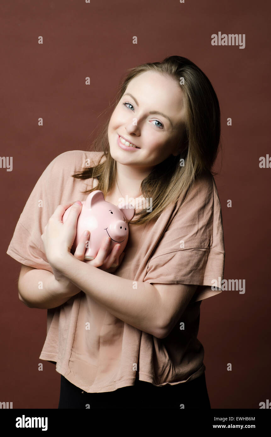 Smiling your woman holding a piggy bank Stock Photo - Alamy