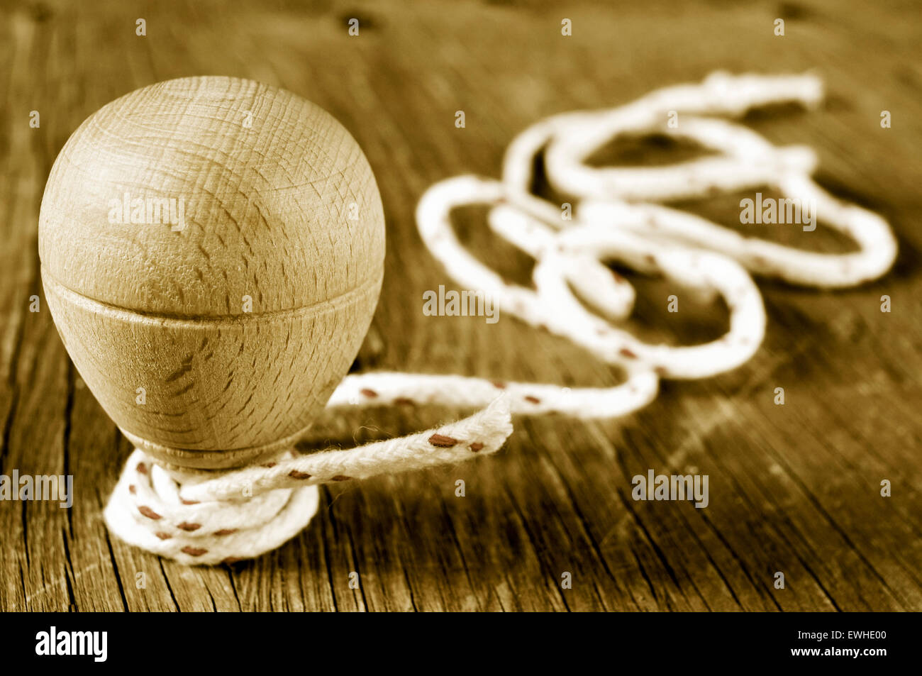 a traditional wooden spinning top with a string coiled in its axis on a