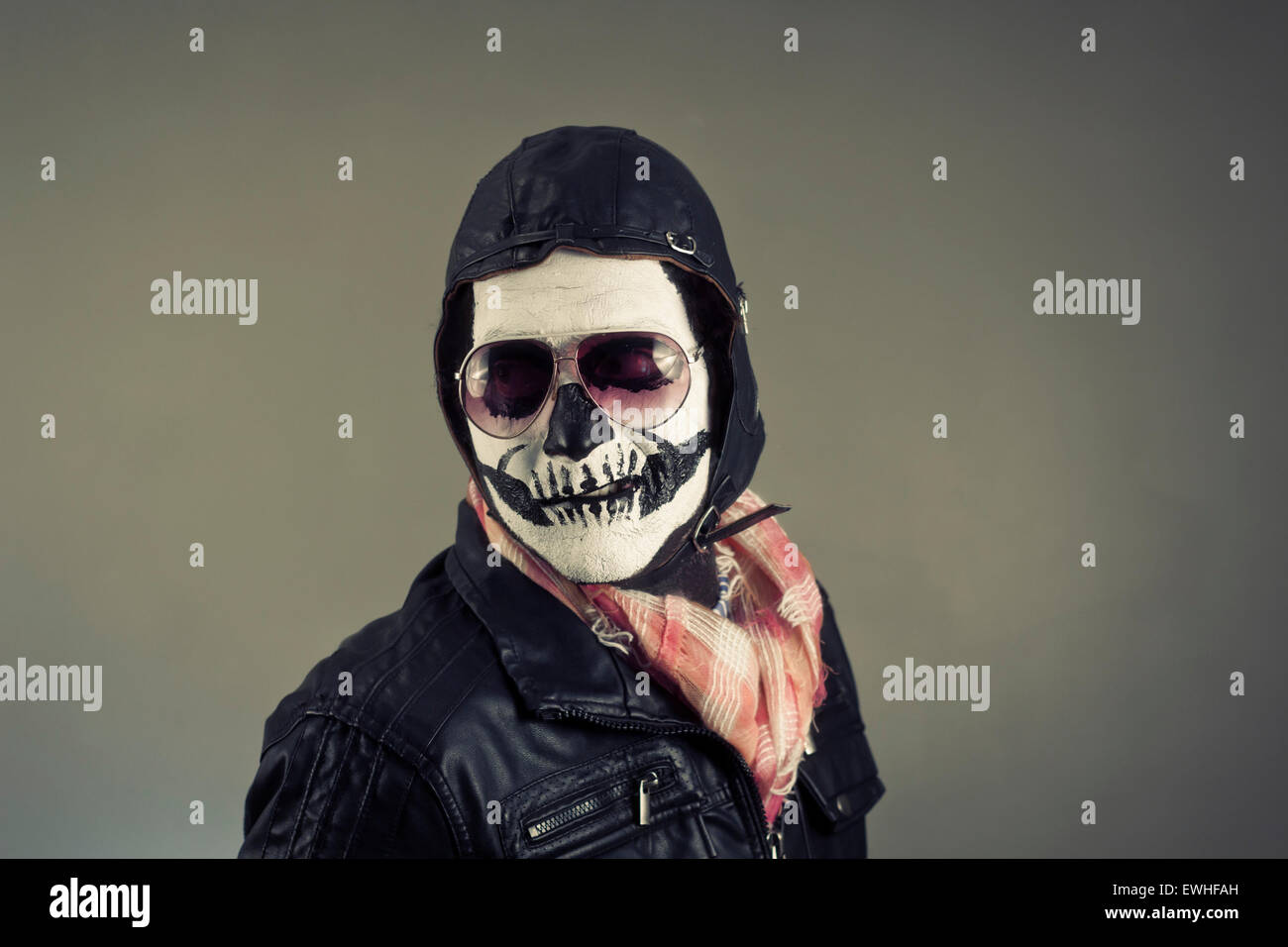 Disapproving aviator with face painted as human skull Stock Photo