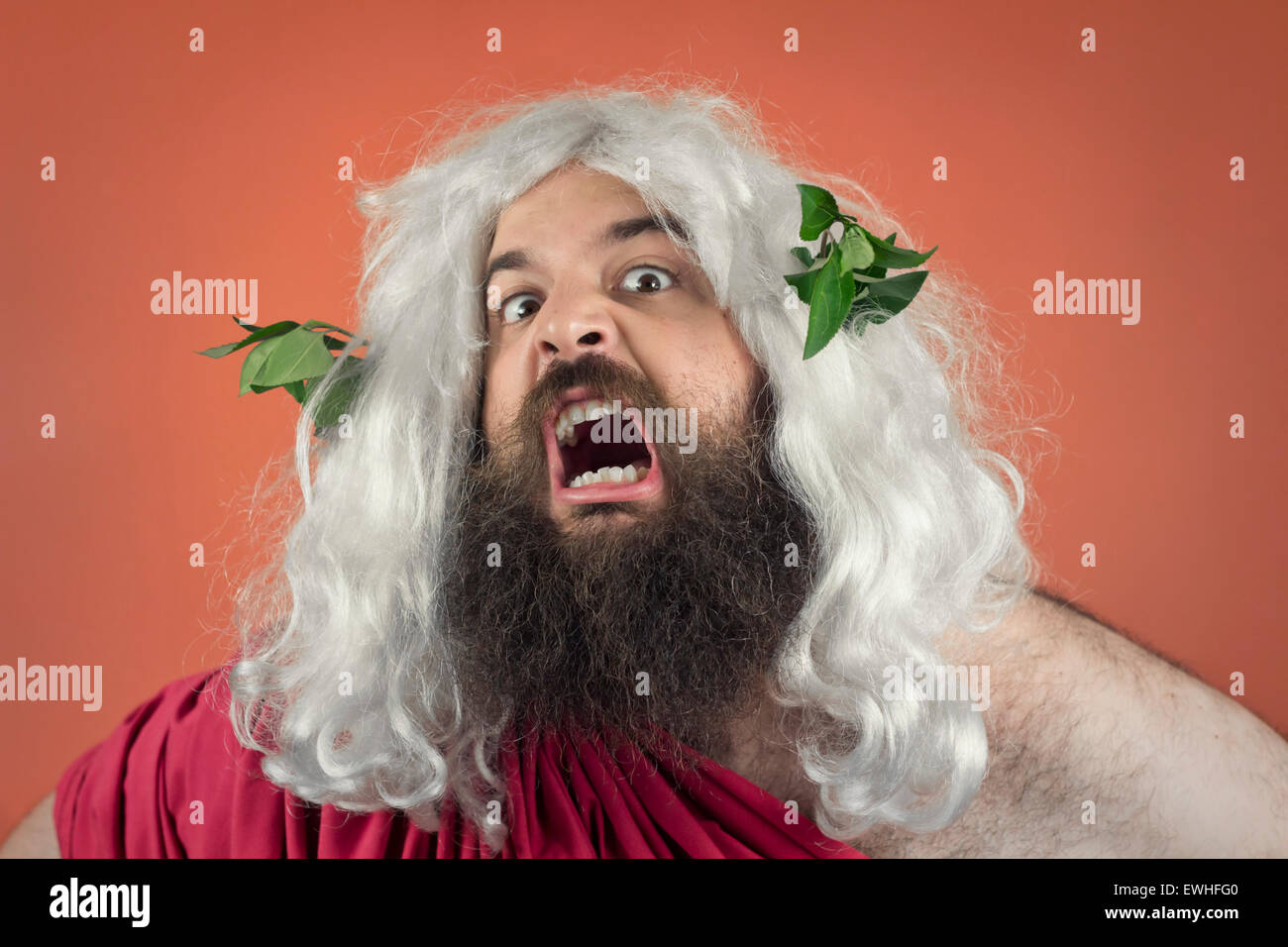 Angry yelling wrath of god against orange background Stock Photo