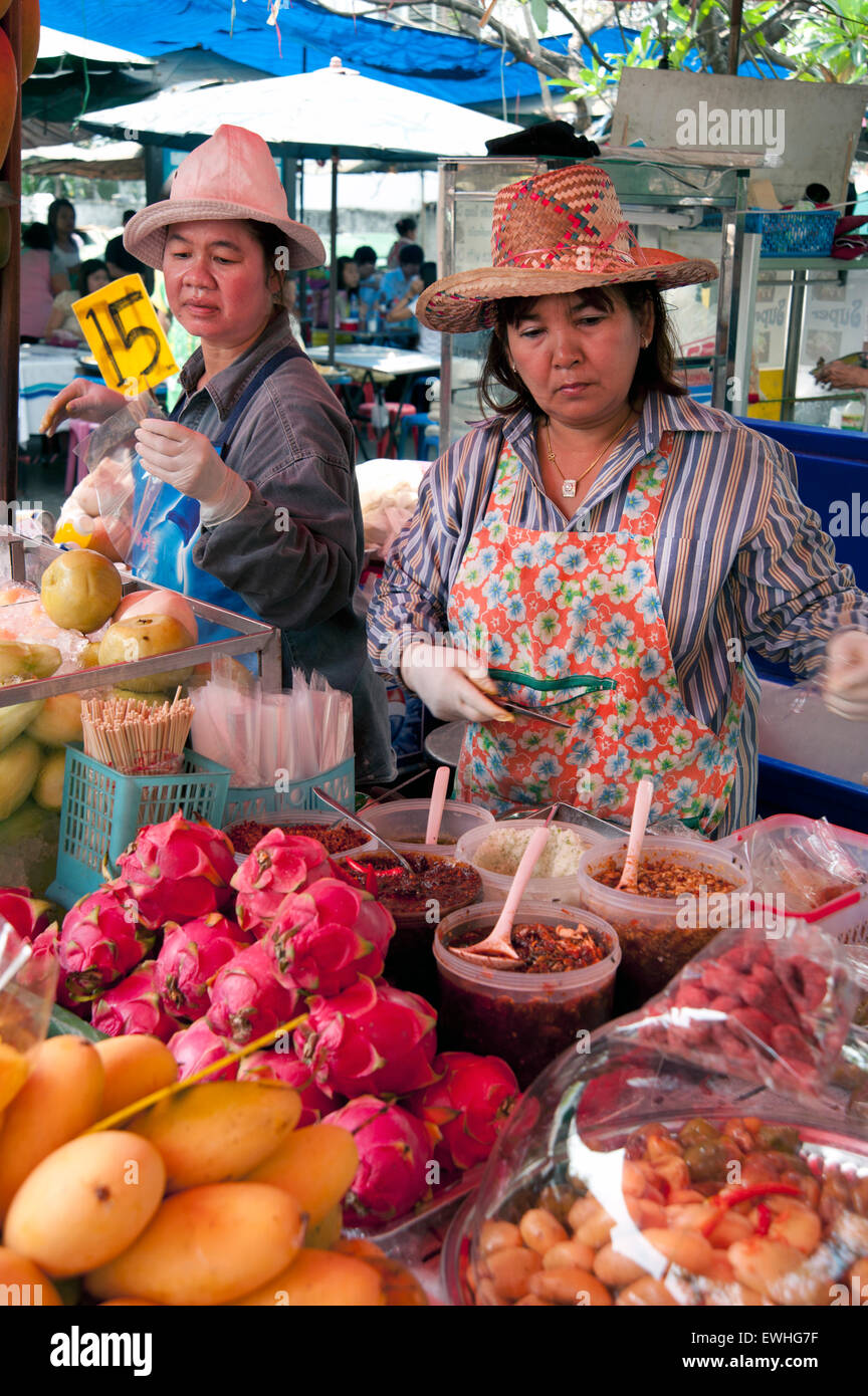 Two Thai ladies working on their fresh fruit stall in a Bangkok Market Thailand Stock Photo