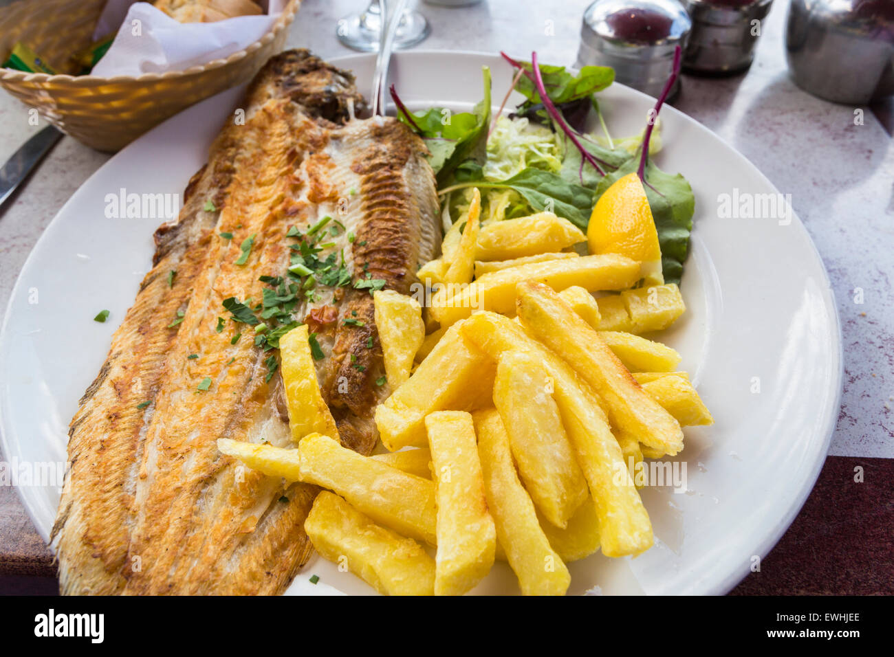 Grilled Dover sole and crispy golden chips (French fries) at a seafood restaurant in Brighton, East Sussex, UK Stock Photo