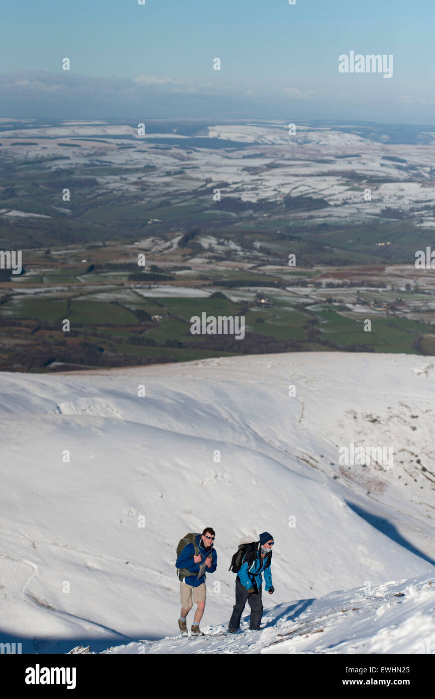 Walkers and climbers in the snow at the summit of Pen y Fan, Brecon, South Wales. Stock Photo