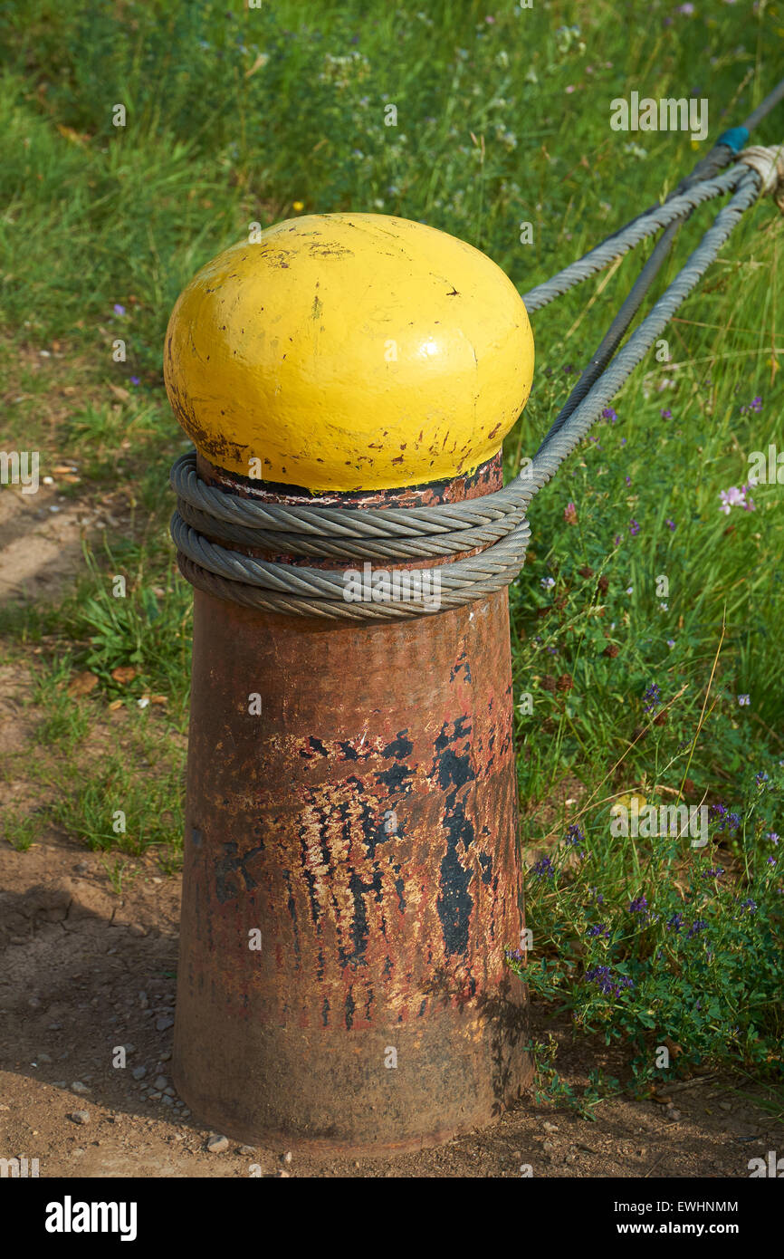 Big Old Ship bollard with steel cables from a ship on the shore Stock
