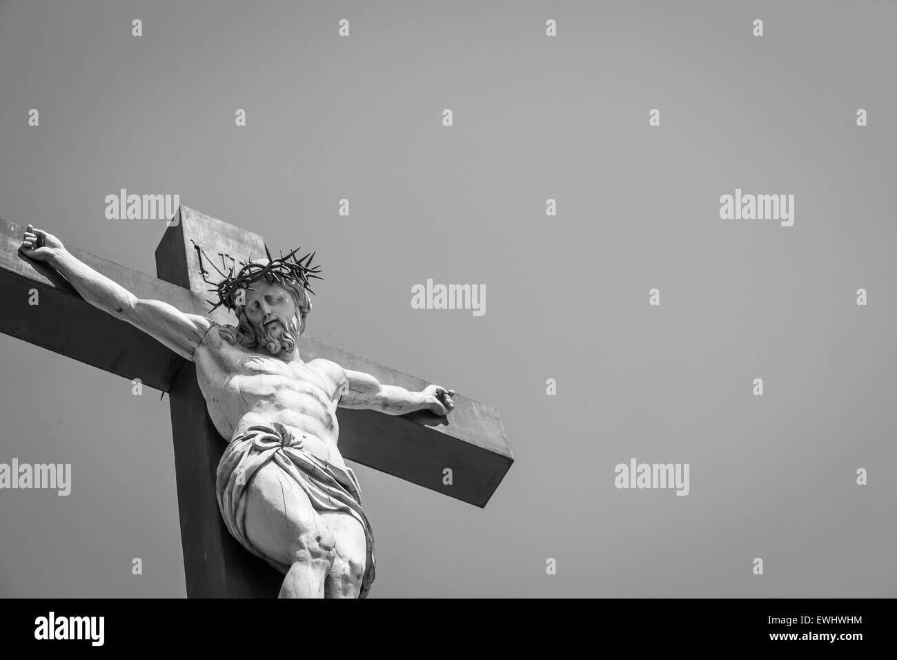 Crucifix made of marble with blue sky in background. France, Provence Region. Stock Photo