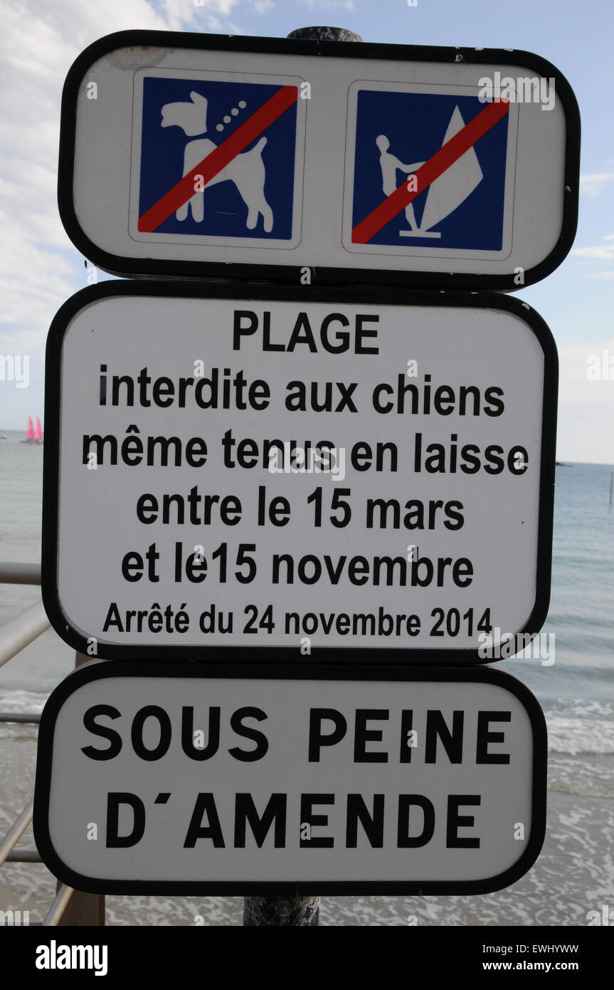 A sign indicating that dogs, even those on leads, are banned from this beach in Brittany, France for 8 months a year. Stock Photo