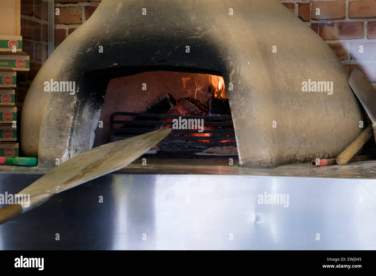 A pizza peel or shovel being used to insert and remove pizzas in a