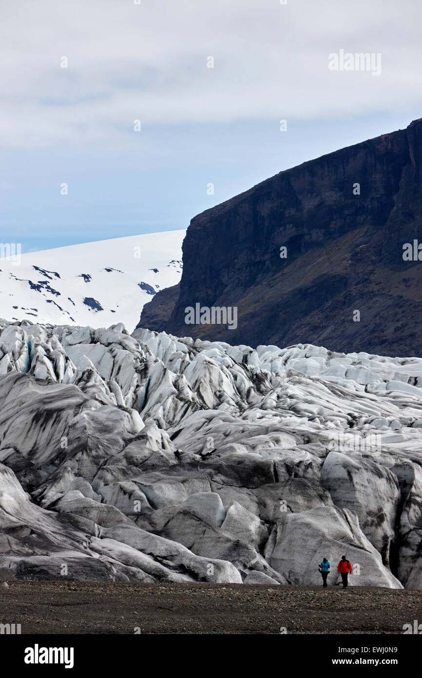 tourist couple at the end of Skaftafell glacier Vatnajokull national park in Iceland Stock Photo