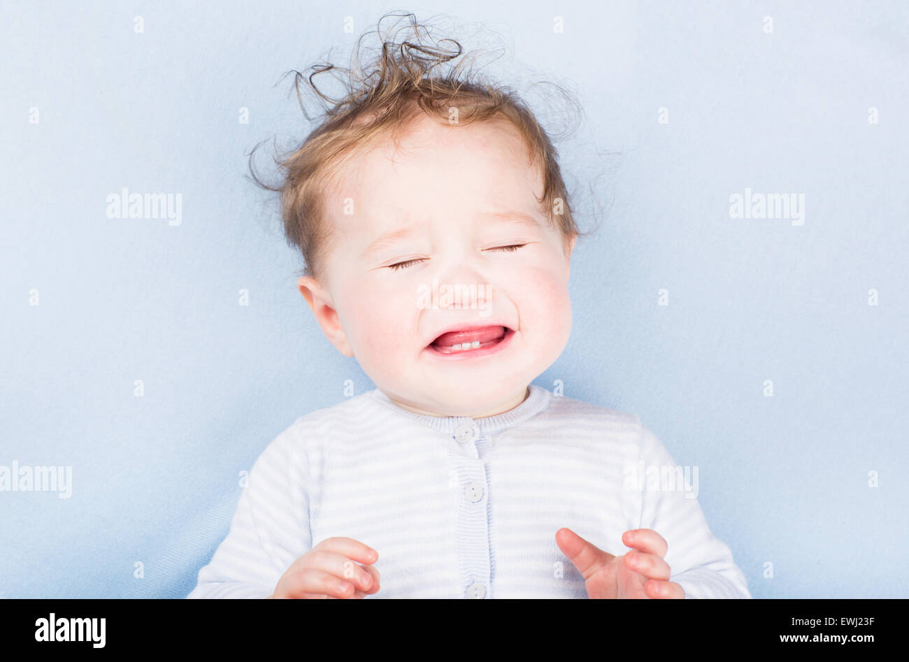 Little crying baby on a blue blanket Stock Photo Alamy