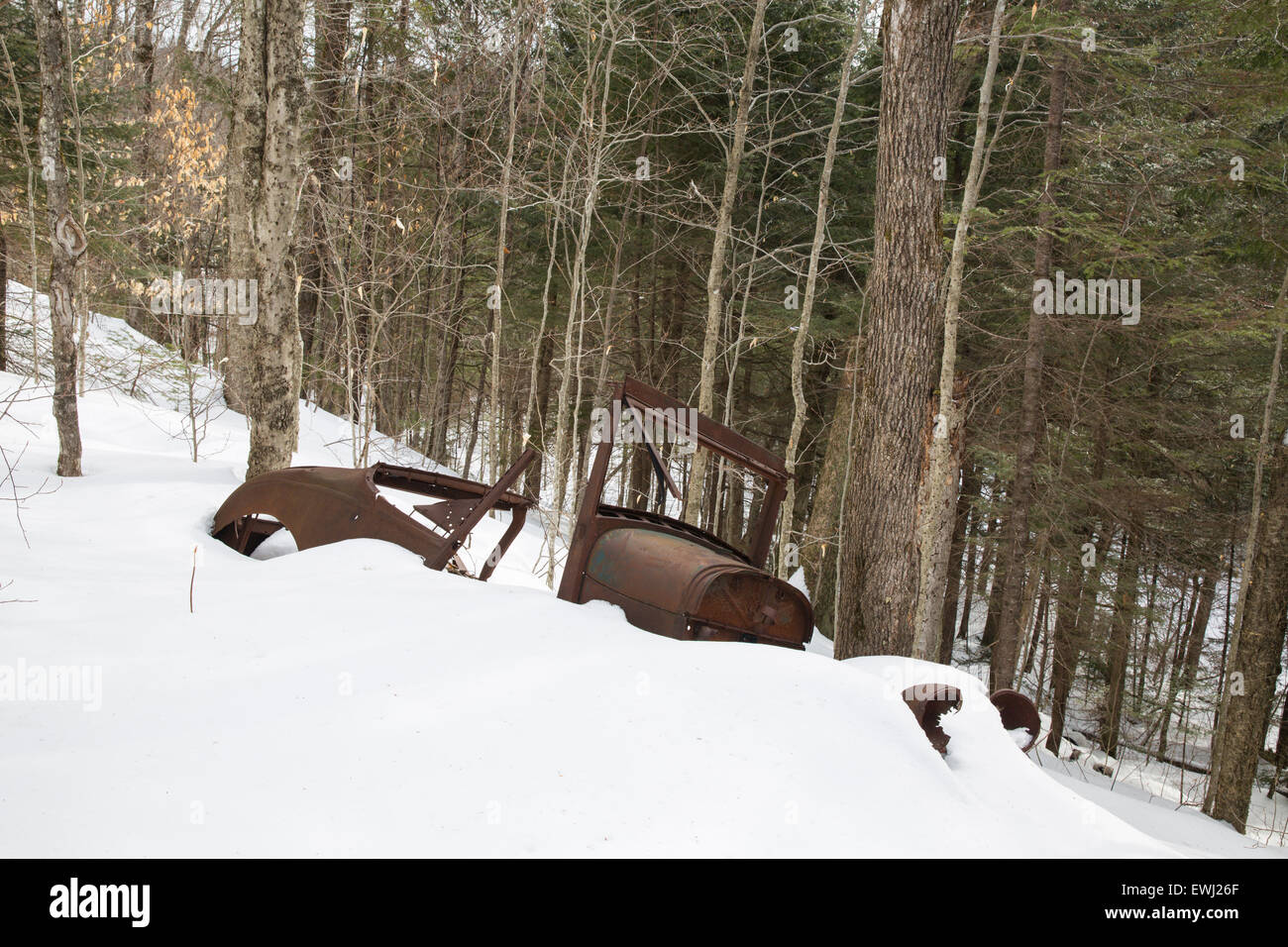 Rusted car in the Eastman Brook drainage of Thornton, New Hampshire USA during the winter months. This is possibly a late 1920s  Stock Photo