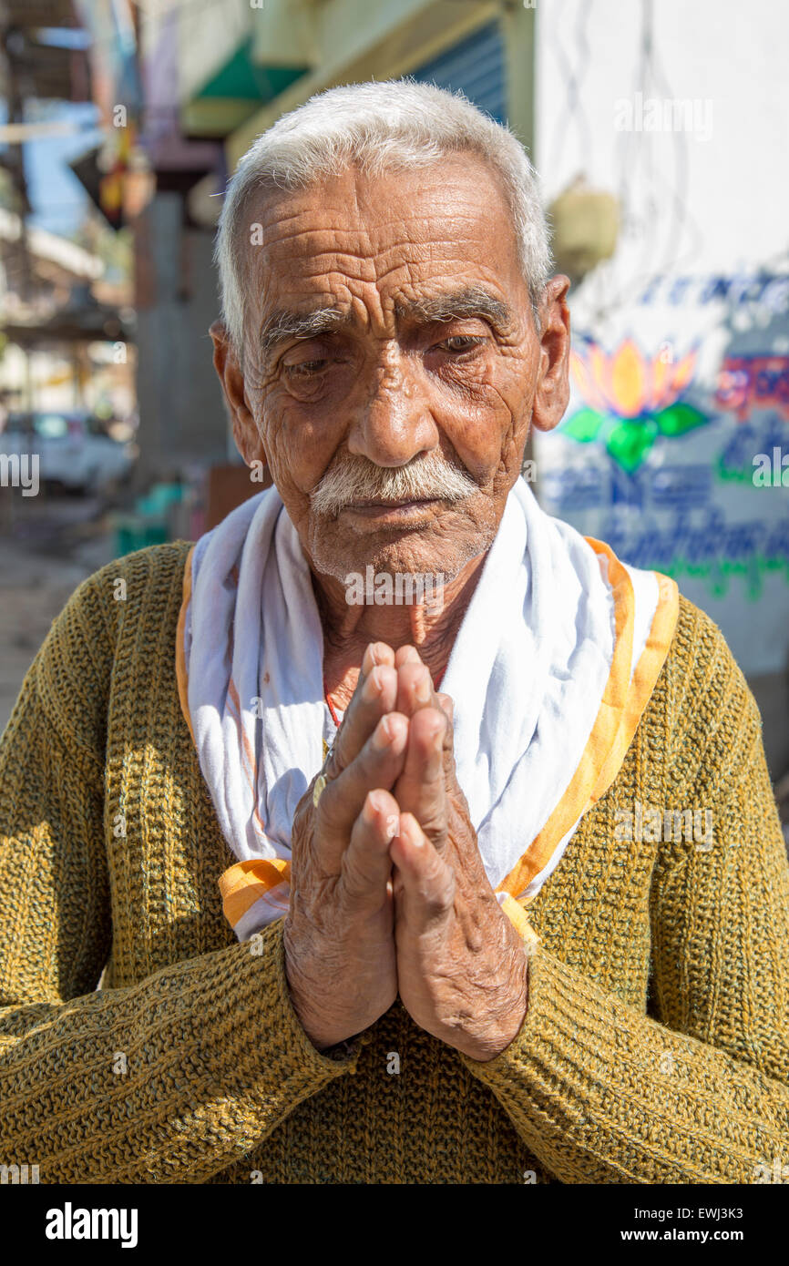 Old Indian man greeting with his palms together in a namaste gesture. Stock Photo