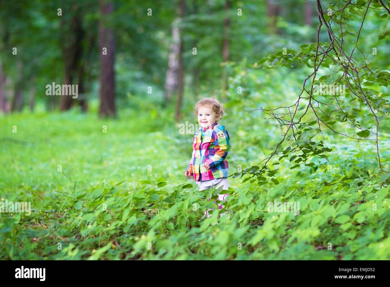 Adorable little girl playing in an autumn park Stock Photo - Alamy