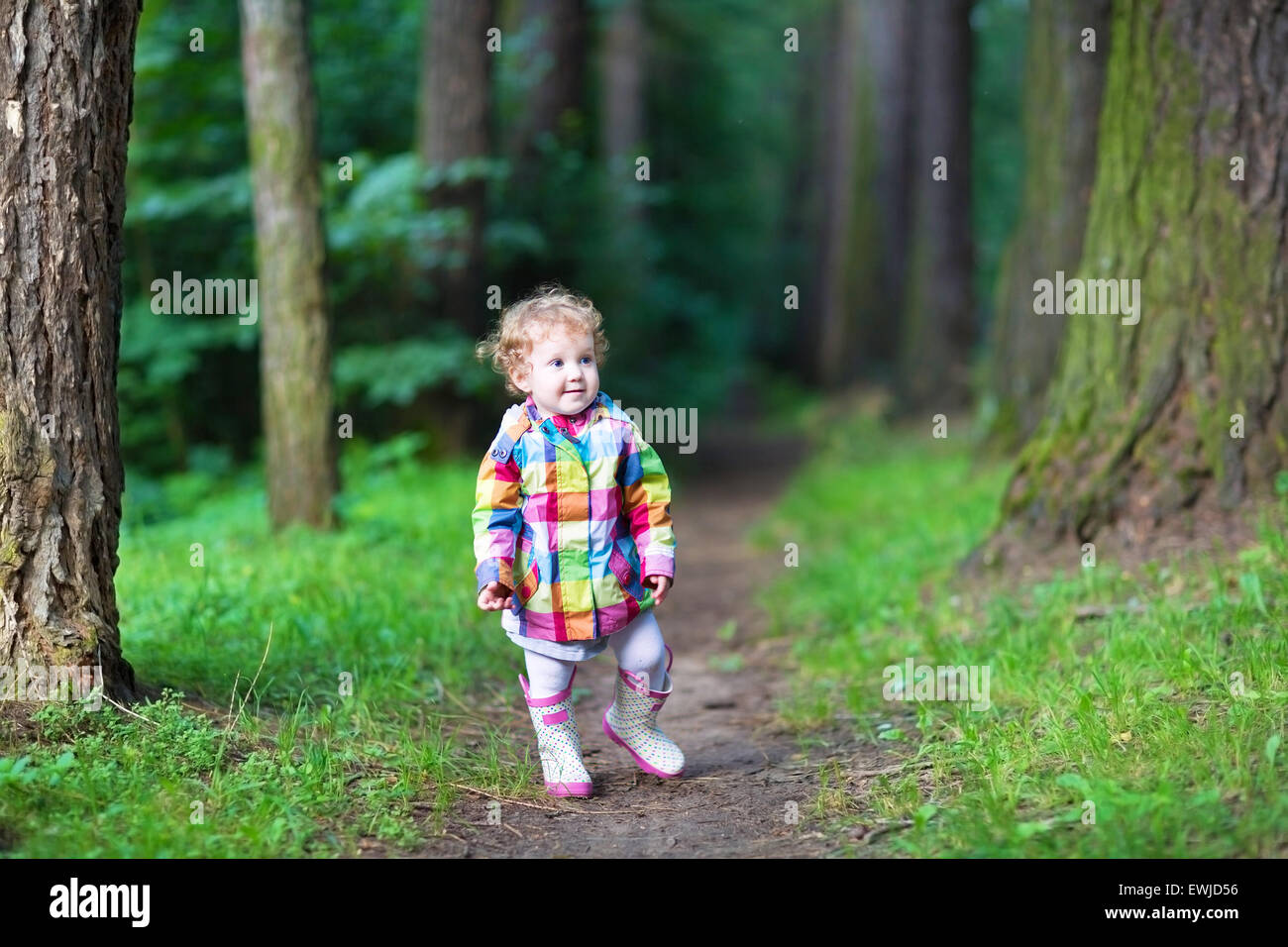 Sweet baby girl in a rain jacket and boots walking in an autumn park Stock Photo Alamy
