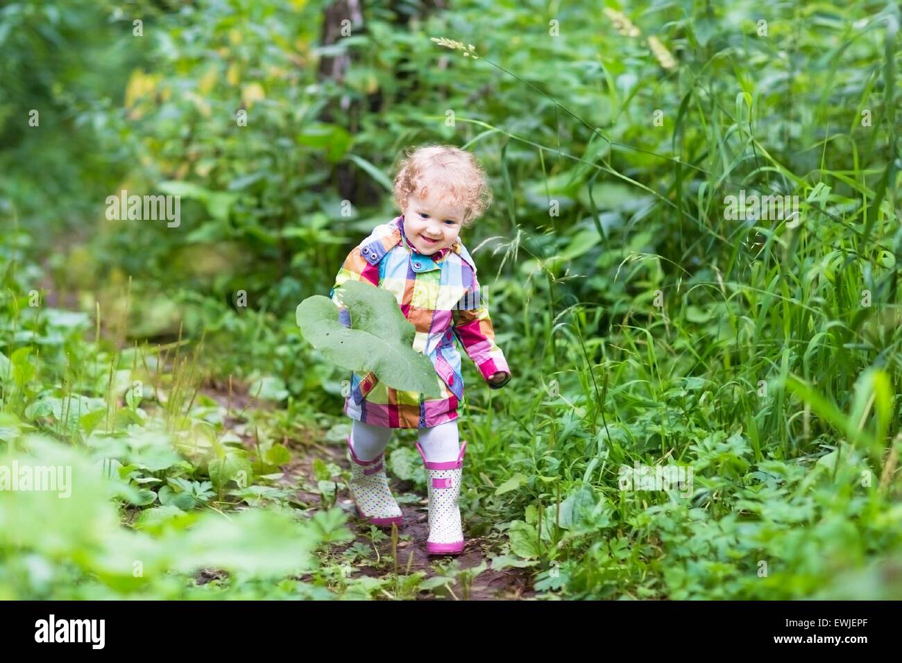 Adorable little girl playing in an autumn park Stock Photo - Alamy