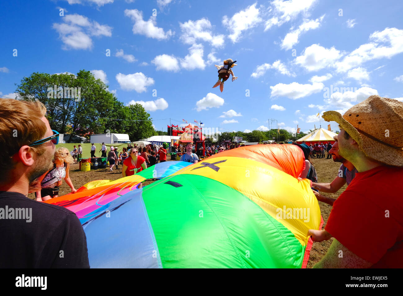 Glastonbury Festival, Somerset, UK. 27 June 2015. Rain, what rain. As Saturday turns into a scorcher crowds flock to the Theatre and Circus area where some take part in 'parachute games' where they toss a small puppet into the air. Credit:  Tom Corban/Alamy Live News Stock Photo