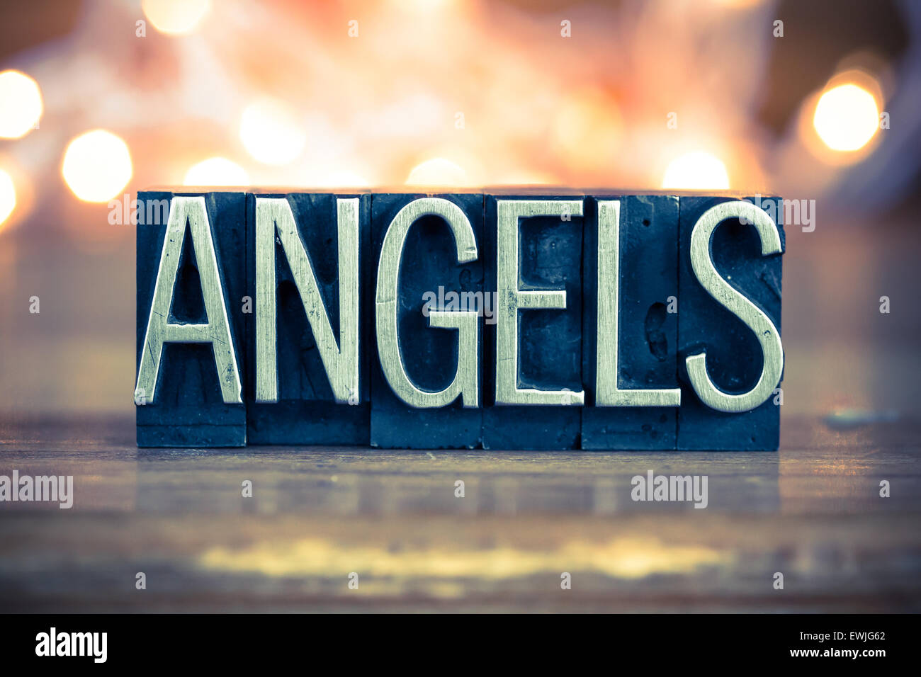 The word ANGELS written in vintage metal letterpress type on a soft backlit background. Stock Photo