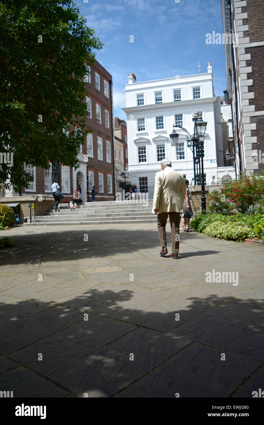 A grey haired, elderly English gentleman takes a leisurely stroll in Deveraux Court in London's Inner Temple, London, England, U.K. Stock Photo