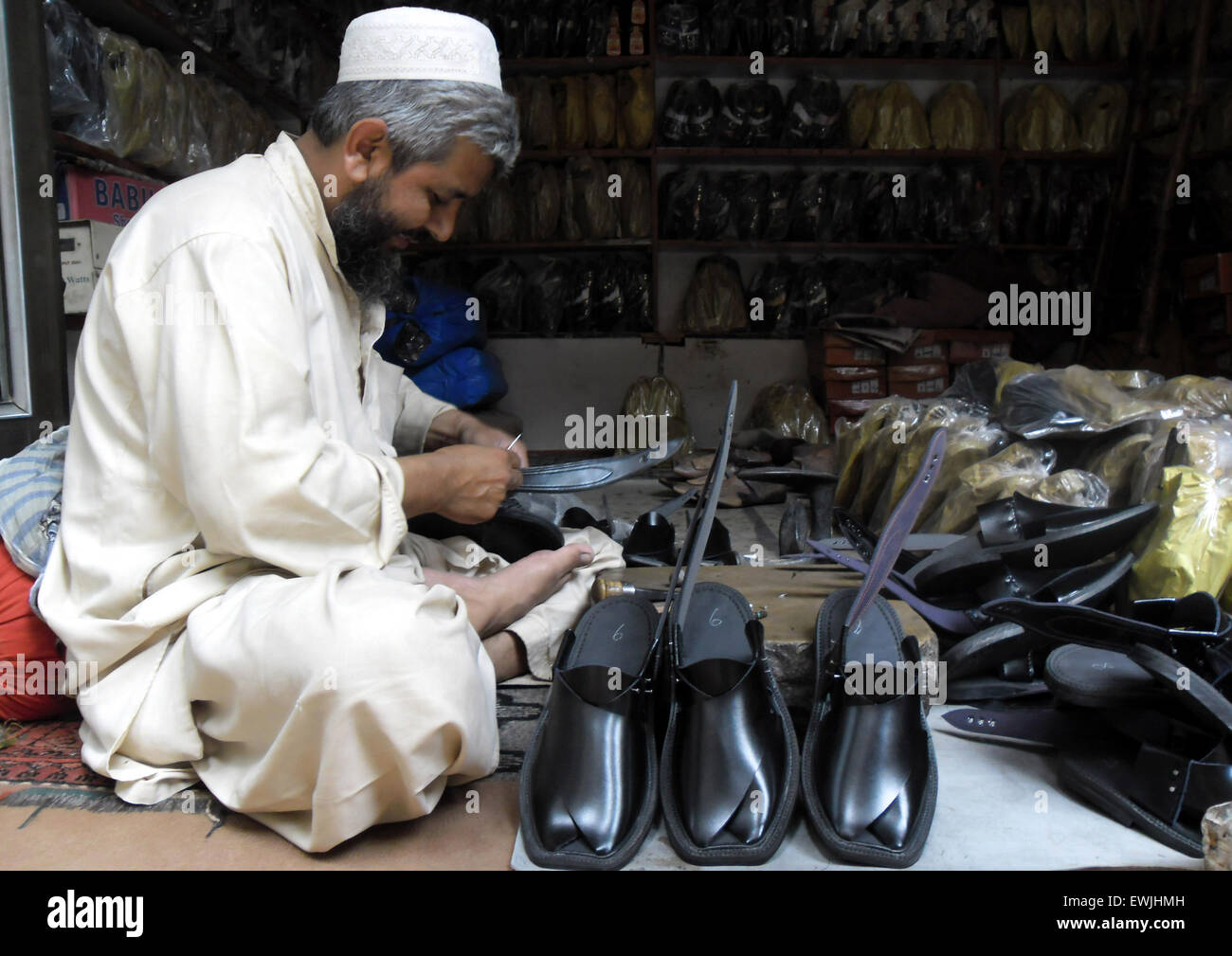 Peshawar. 27th June, 2015. A Pakistani man makes traditional Peshawari Chappal at a workshop in northwest Pakistan's Peshawar, June 27, 2015. Peshawari Chappal is a traditional footwear of Pakistan, worn especially by Pashtuns in the Khyber Pakhtunkhwa region of Pakistan. © Ahmad Sidique/Xinhua/Alamy Live News Stock Photo