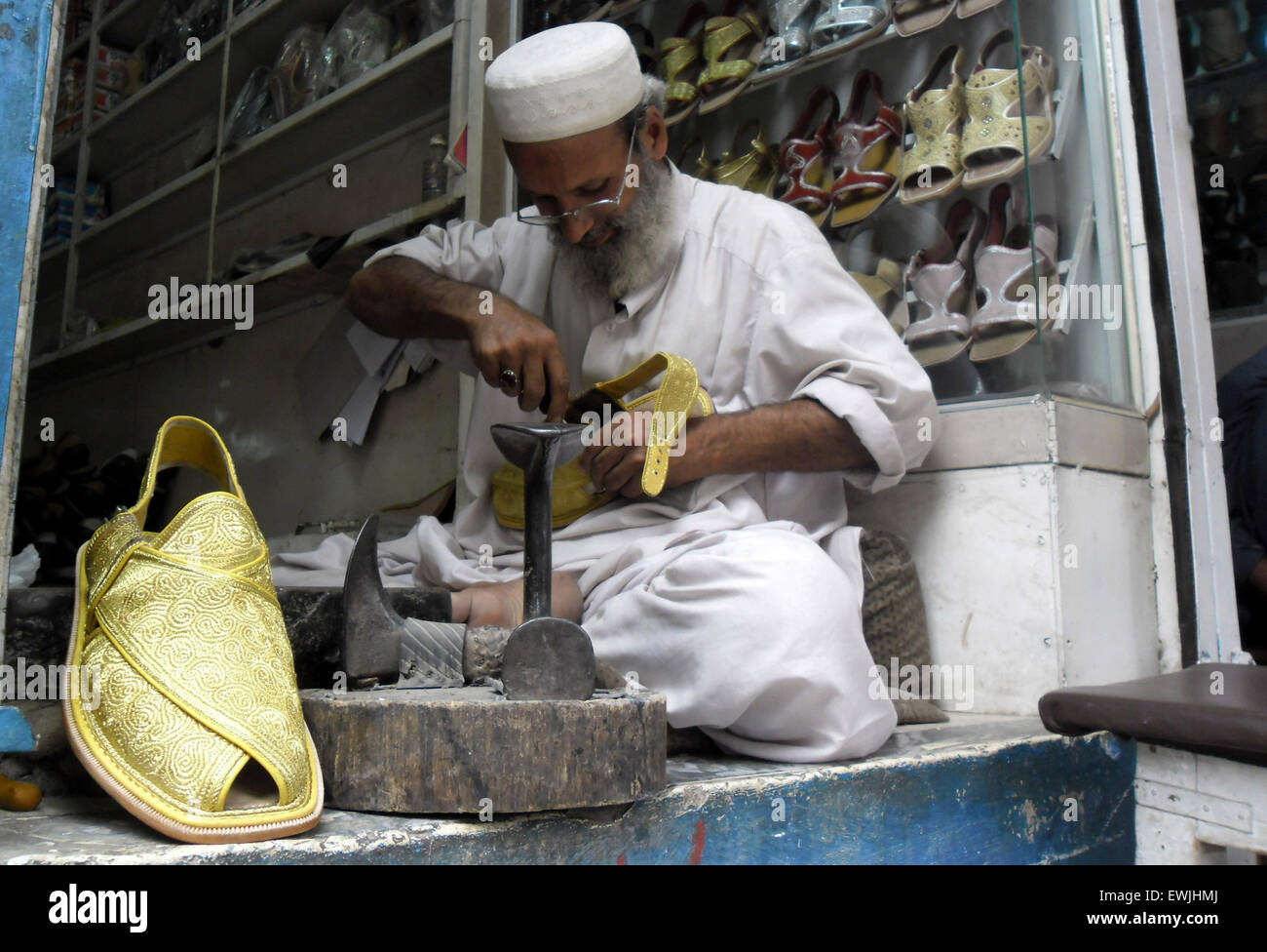 Peshawar. 27th June, 2015. A Pakistani man prepares traditional Peshawari Chappal at a workshop in northwest Pakistan's Peshawar, June 27, 2015. Peshawari Chappal is a traditional footwear of Pakistan, worn especially by Pashtuns in the Khyber Pakhtunkhwa region of Pakistan. © Ahmad Sidique/Xinhua/Alamy Live News Stock Photo