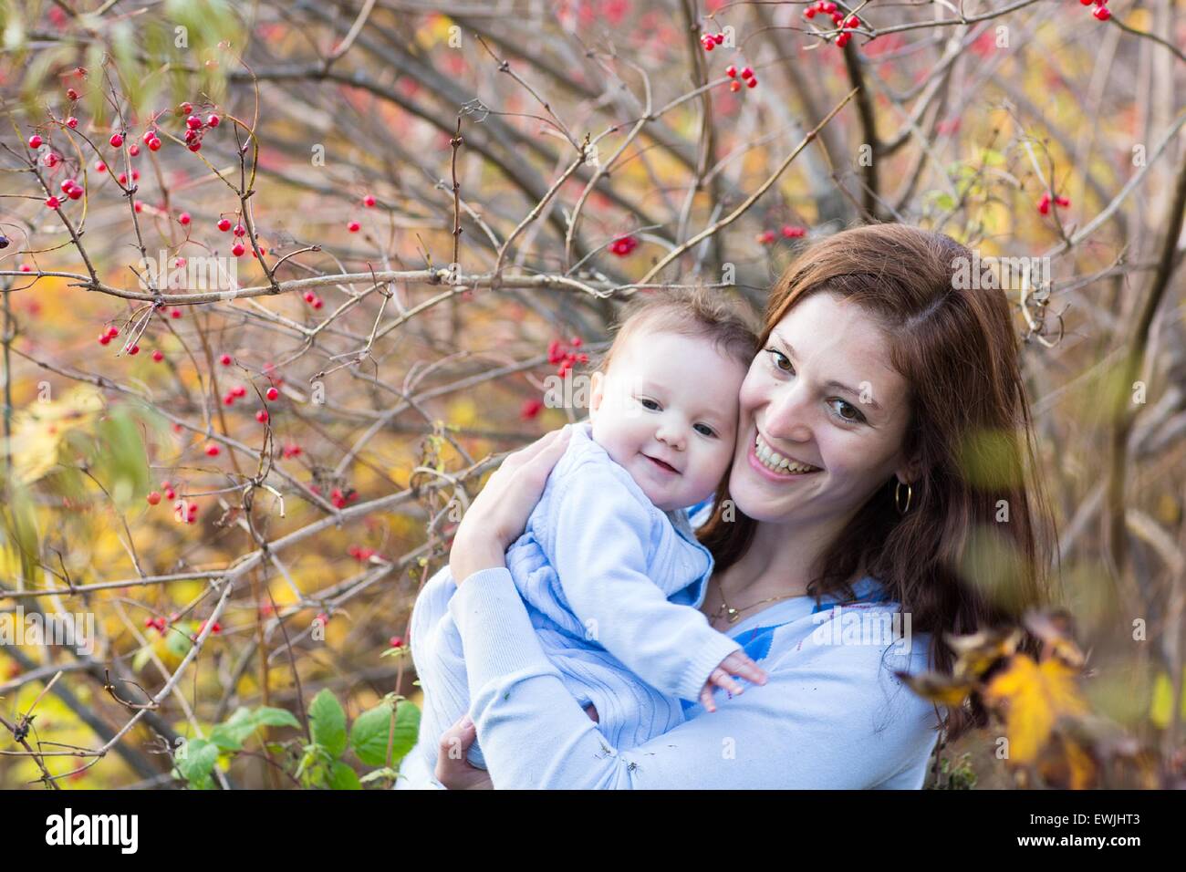 Young happy mother hugging her little baby in a sunny autumn park Stock ...