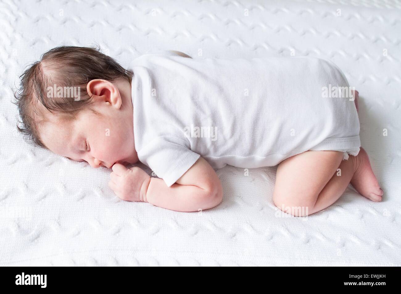 Tiny newborn baby sleeping on a white knitted blanket Stock Photo Alamy