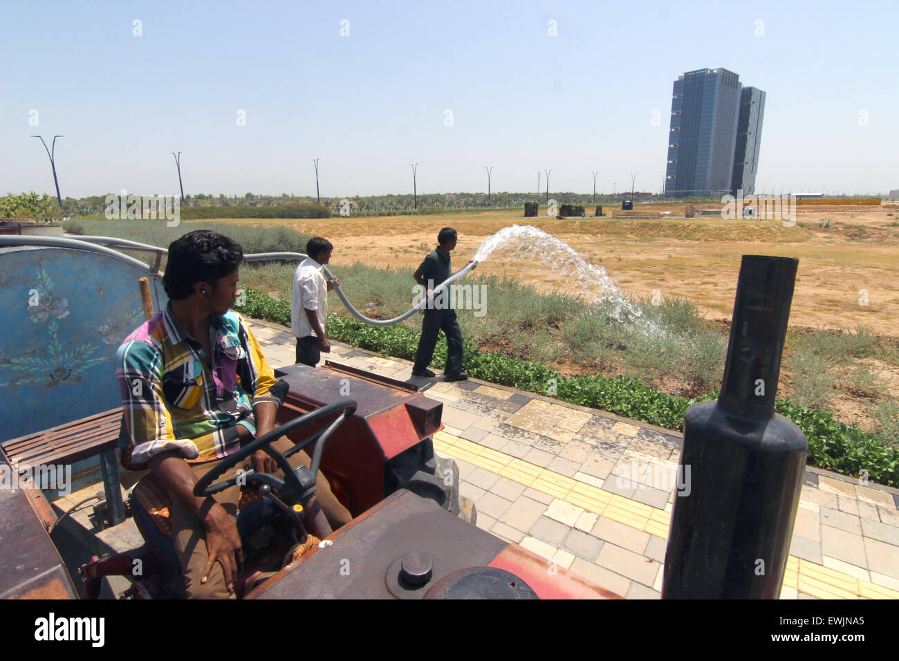 Gandhinagar, India. 16th May, 2015. Gardeners water the plants in the