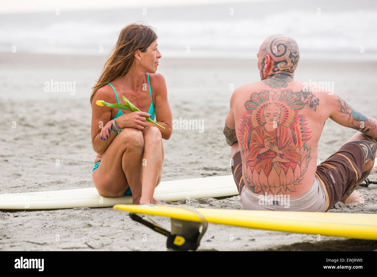 Folly beach, South Carolina, USA. 27th June, 2015. Charleston area surfers gather for a moment of silence before holding a traditional memorial paddle out to honor and remember the nine people killed at the historic mother Emanuel African Methodist Episcopal Church June 27, 2015 in Folly Beach, South Carolina. Earlier in the week a white supremacist gunman killed 9 members at the historically black church. Stock Photo