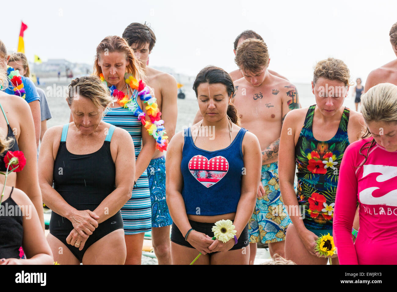 Folly beach, South Carolina, USA. 27th June, 2015. Charleston area surfers gather for a moment of silence before holding a traditional memorial paddle out to honor and remember the nine people killed at the historic mother Emanuel African Methodist Episcopal Church June 27, 2015 in Folly Beach, South Carolina. Earlier in the week a white supremacist gunman killed 9 members at the historically black church. Credit:  Planetpix/Alamy Live News Stock Photo