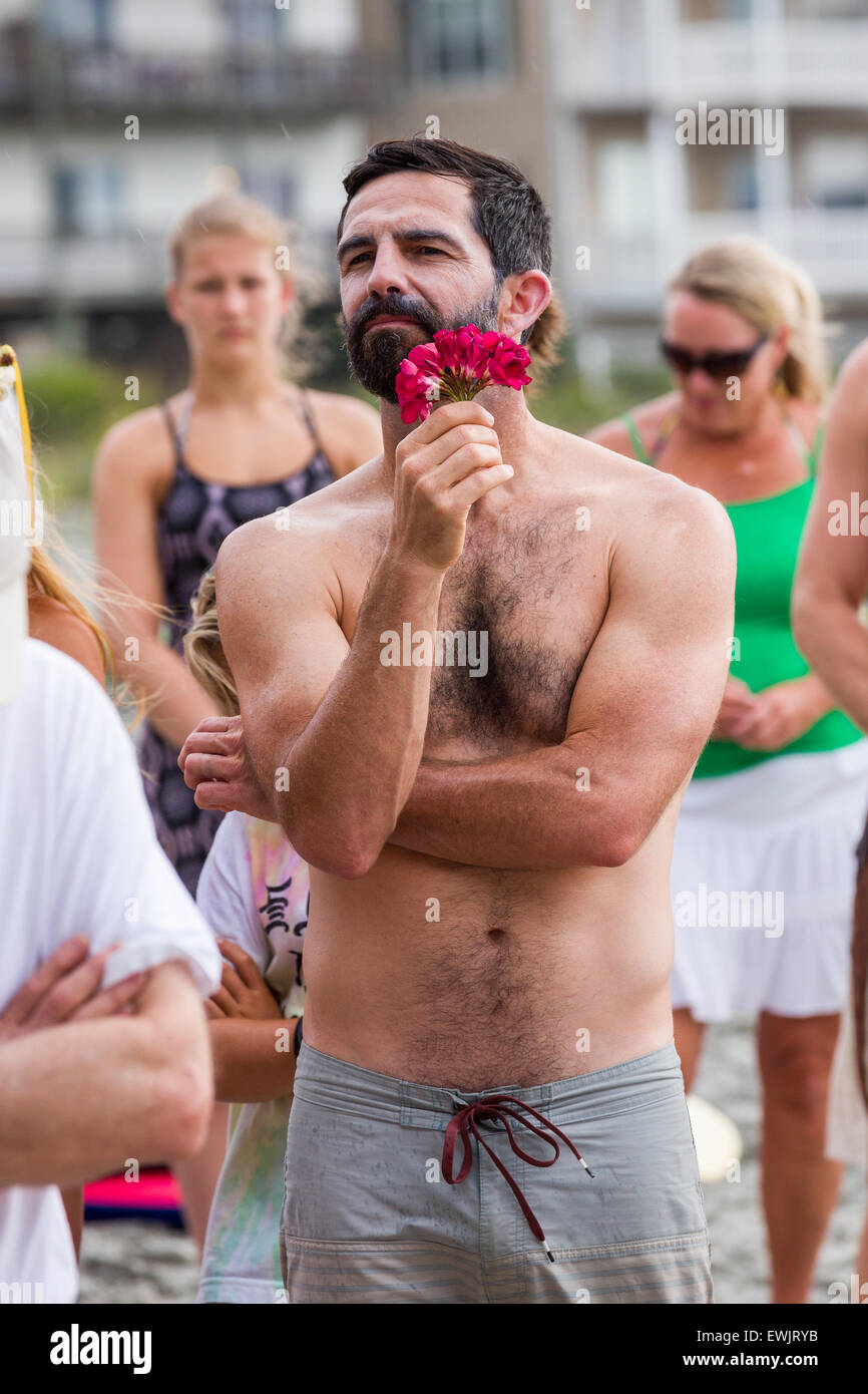 Folly beach, South Carolina, USA. 27th June, 2015. Charleston area surfers gather for a moment of silence before holding a traditional memorial paddle out to honor and remember the nine people killed at the historic mother Emanuel African Methodist Episcopal Church June 27, 2015 in Folly Beach, South Carolina. Earlier in the week a white supremacist gunman killed 9 members at the historically black church. Stock Photo