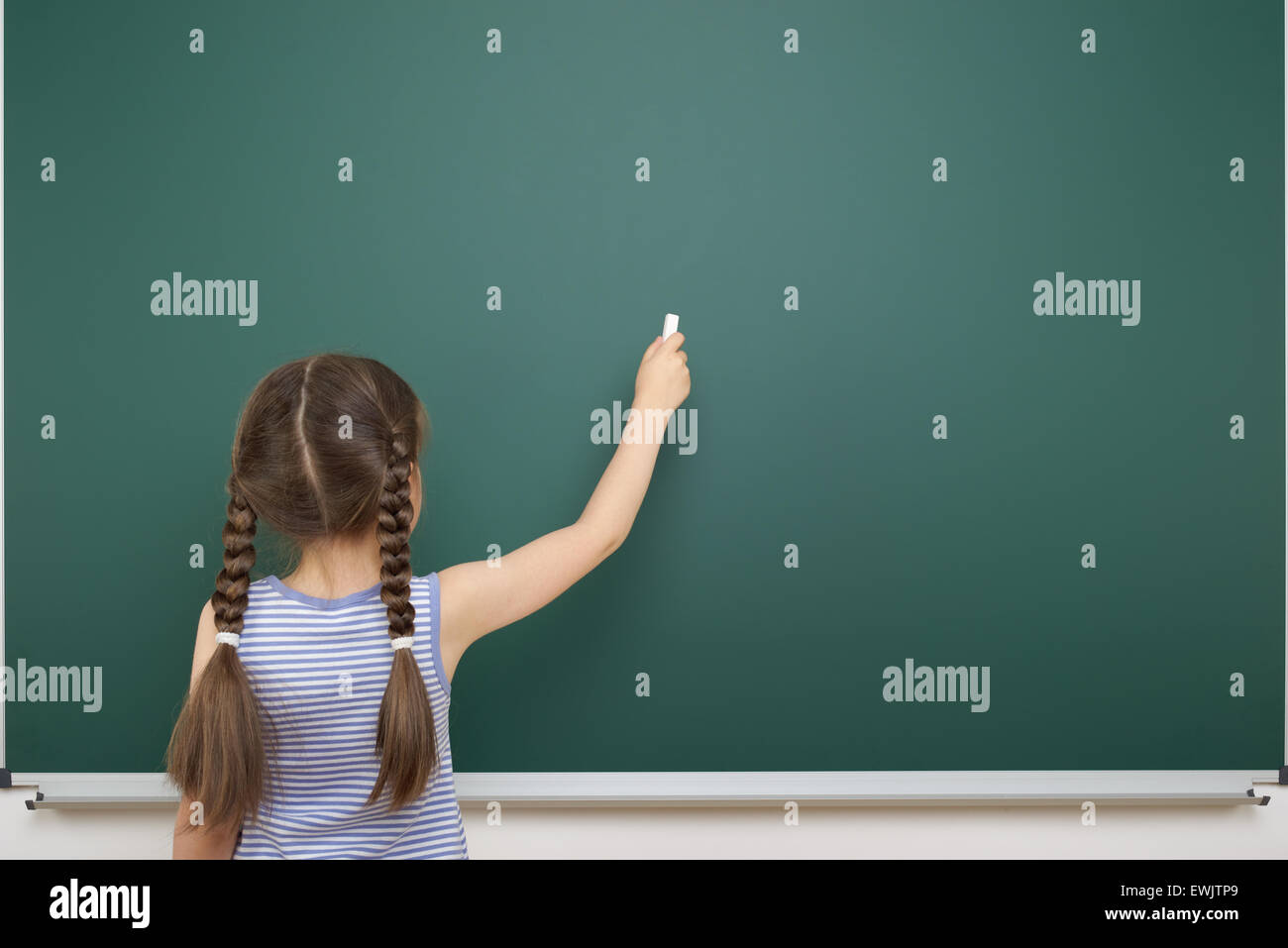 Schoolgirl near the school board Stock Photo - Alamy