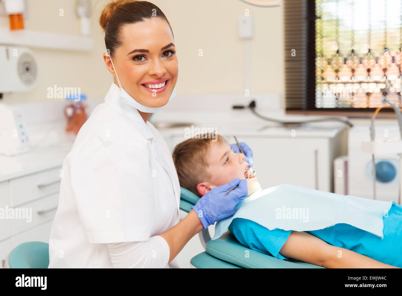 beautiful young dentist and little patient in clinic Stock Photo