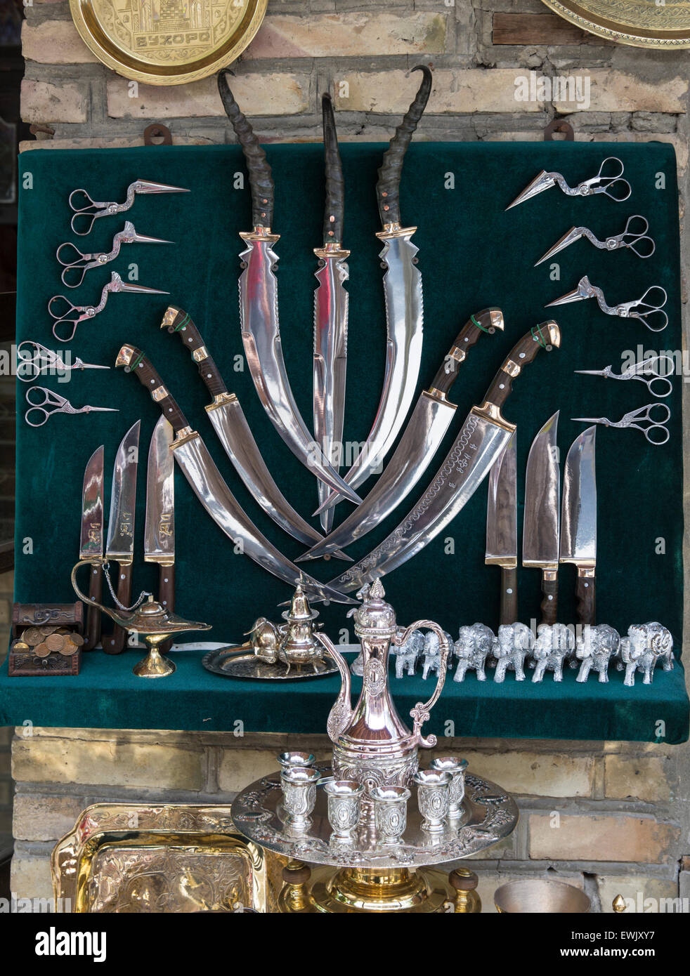 Knives and other objects at a metalsmith's shop in the ancient, walled Silk Road city of Bukhara, Uzbekistan Stock Photo