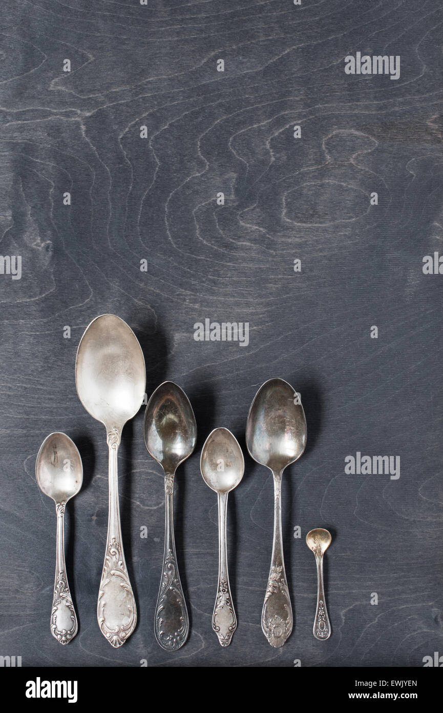 Silver spoons on the dark wooden table Stock Photo