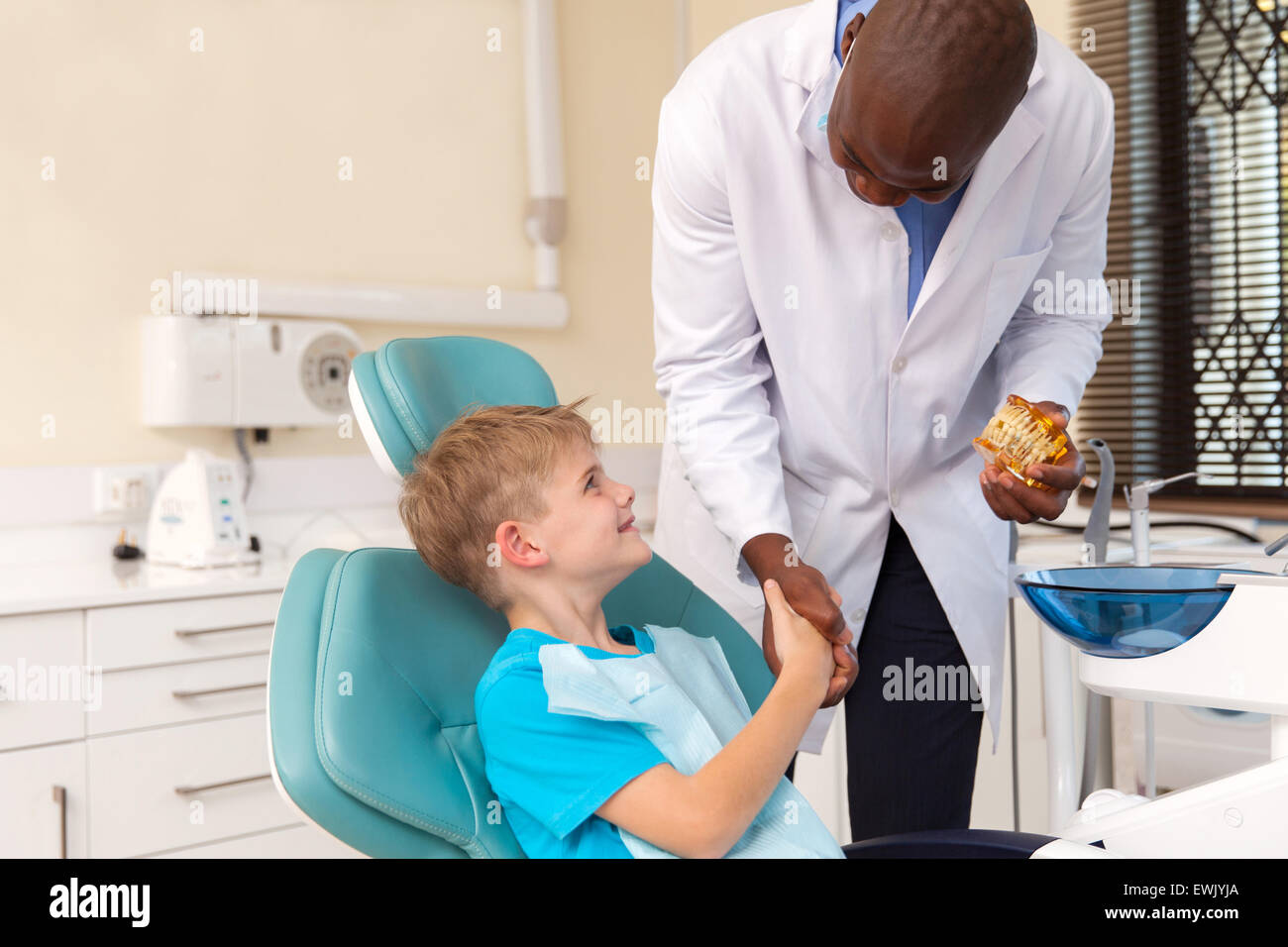 African American doctor handshaking little patient after successful operation Stock Photo