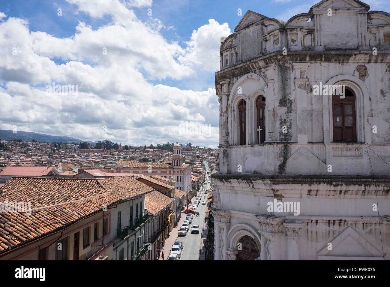 View of street and white colonial building in Cuenca, Ecuador with a cross in the antique window. Stock Photo
