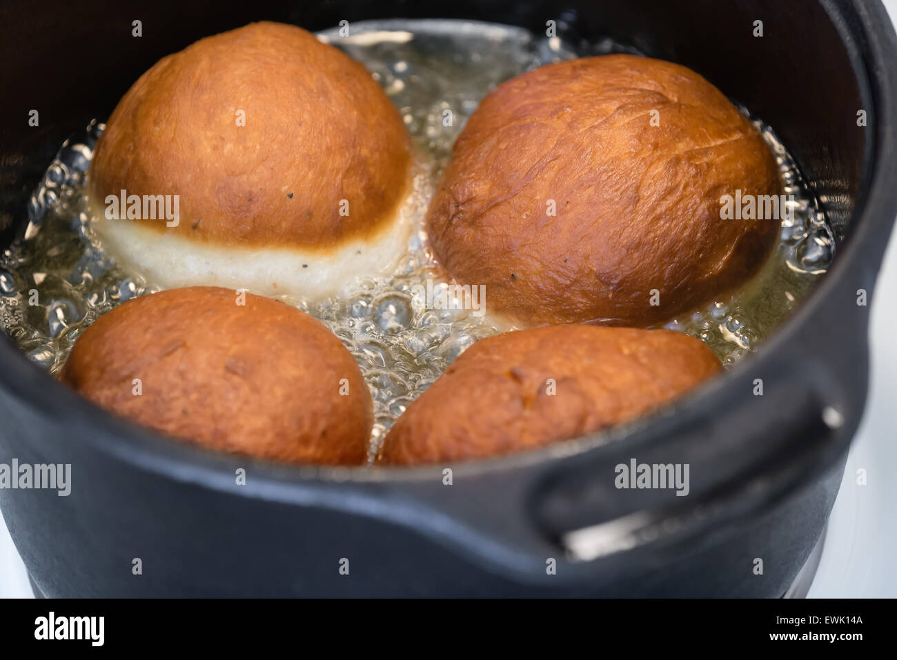 Homemade doughnuts deep-frying in oil Stock Photo