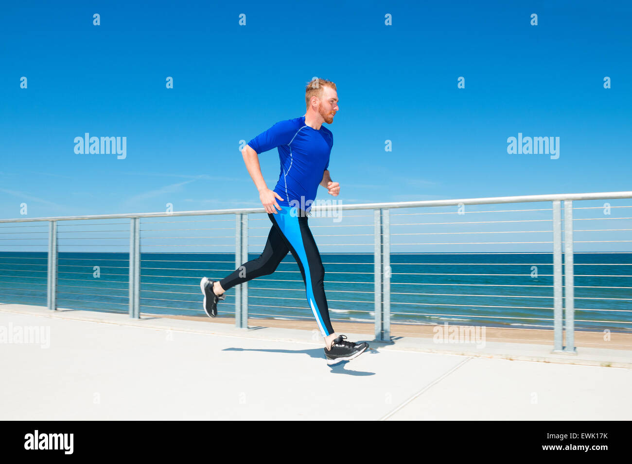 Man running or jogging at a beachside park. Stock Photo