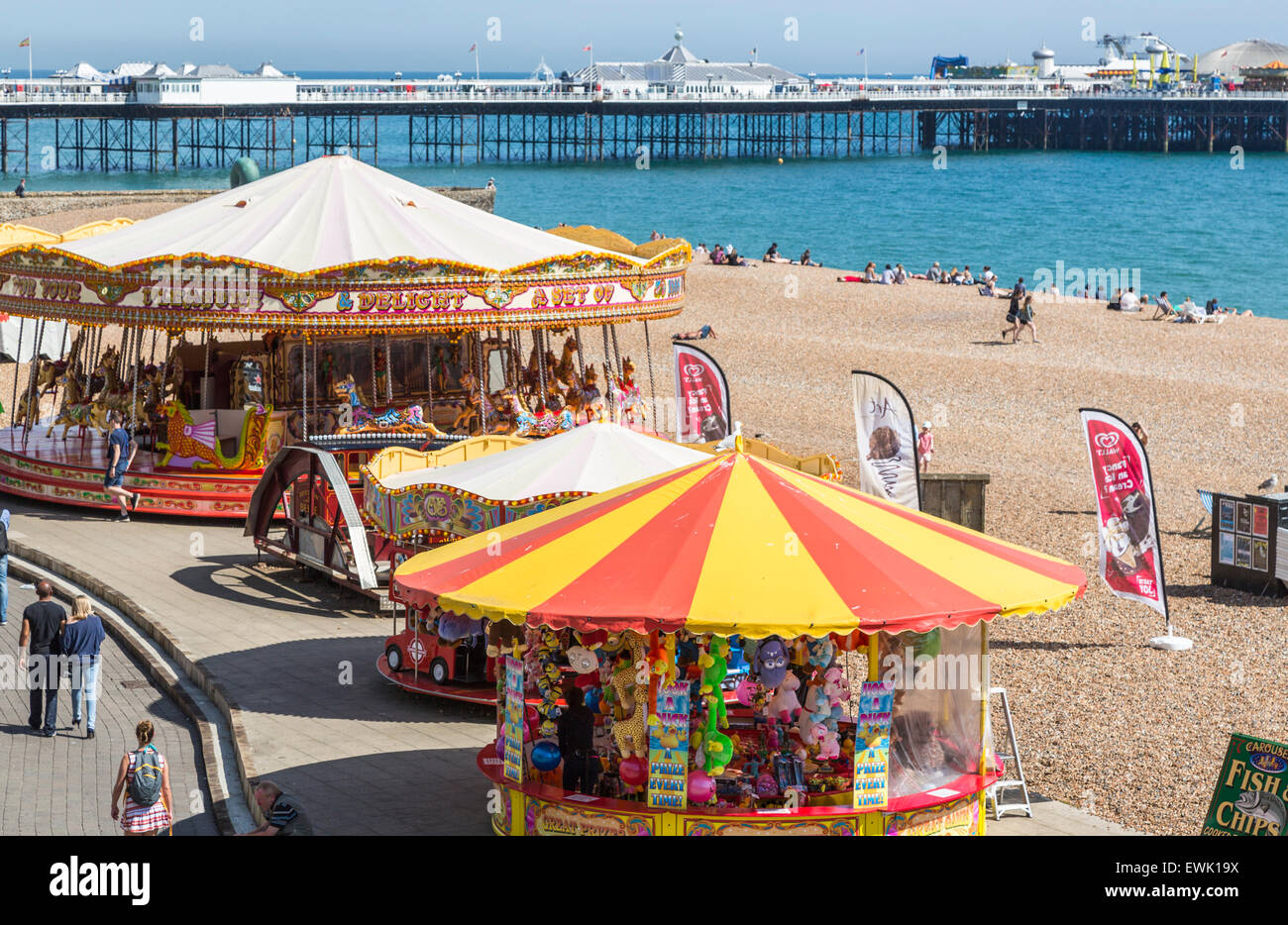 Colourful merry-go-round (carousel) on the seafront promenade and the Palace Pier, Brighton, on a sunny summer day Stock Photo
