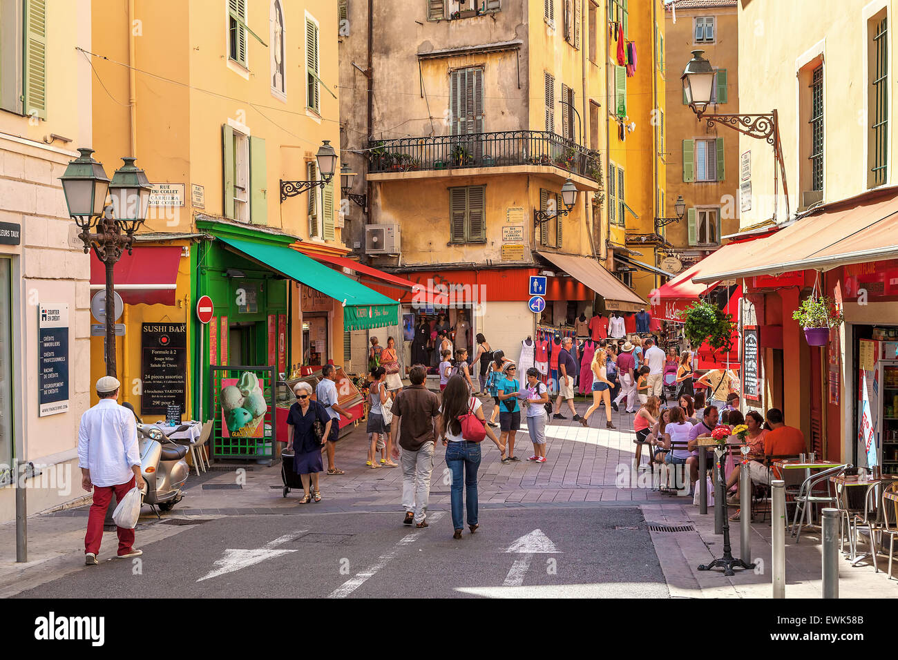 Tourists sitting in outdoor restaurants and walking in Old City of Nice. Stock Photo