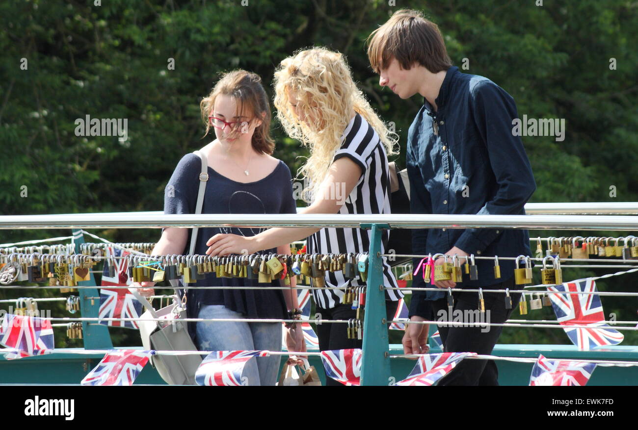 Young people examine love locks on a bridge in Bakewell, Peak District, Derbyshire Stock Photo