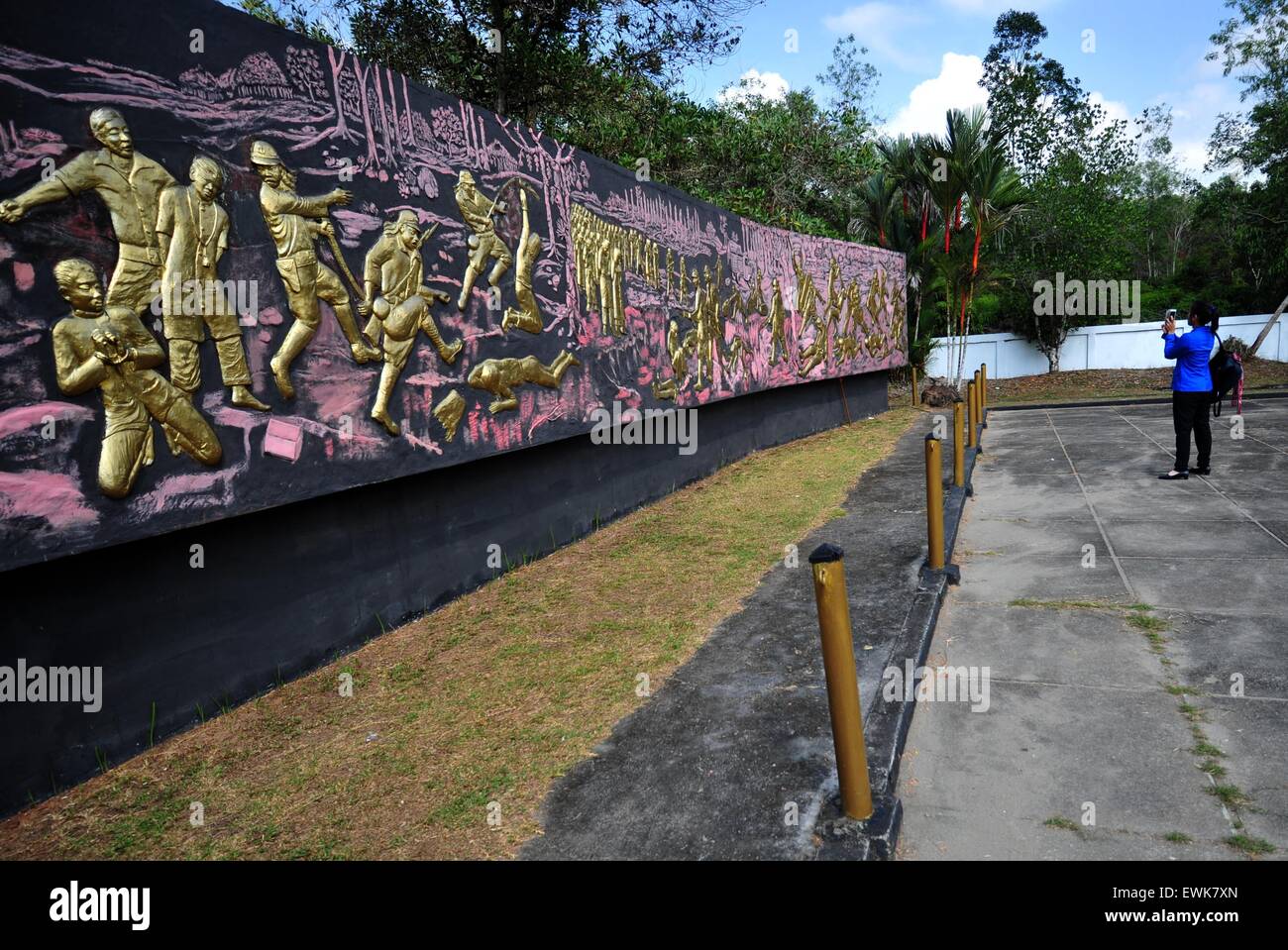 Pontianak, Indonesia. 28th June, 2015. An Indonesian college student takes photos in front of memorial graphics at the Juang Mandor Monument after a memorial ceremony in Mandor town, near Pontianak, capital of West Kalimantan Province, Indonesia, June 28, 2015. People commemorate the massacre of local residents in West Kalimantan by Japanese troops in WWII on Sunday. © Zulkarnain/Xinhua/Alamy Live News Stock Photo