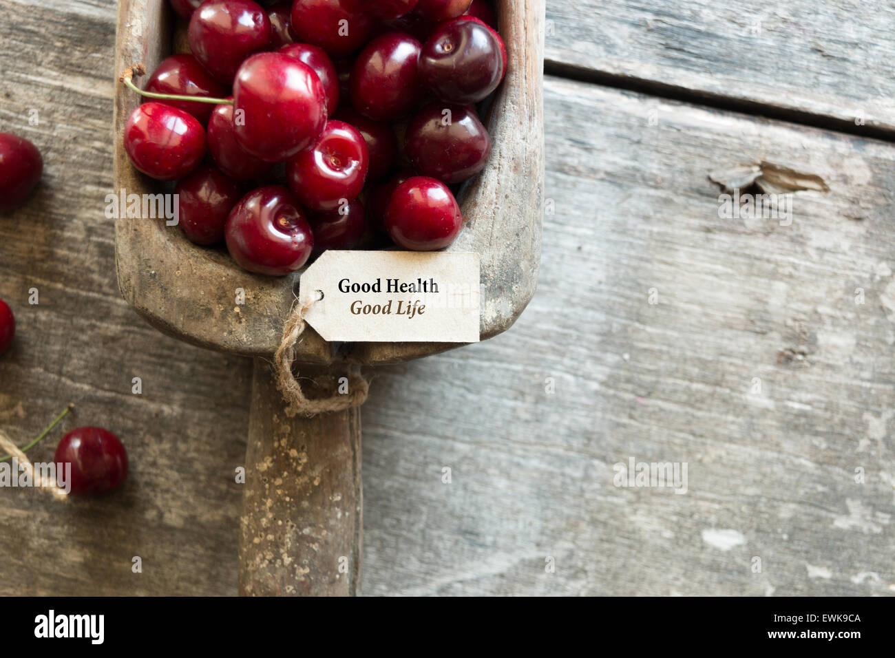 Good health good life. Ripe cherries and an inscription on a wooden table. Stock Photo